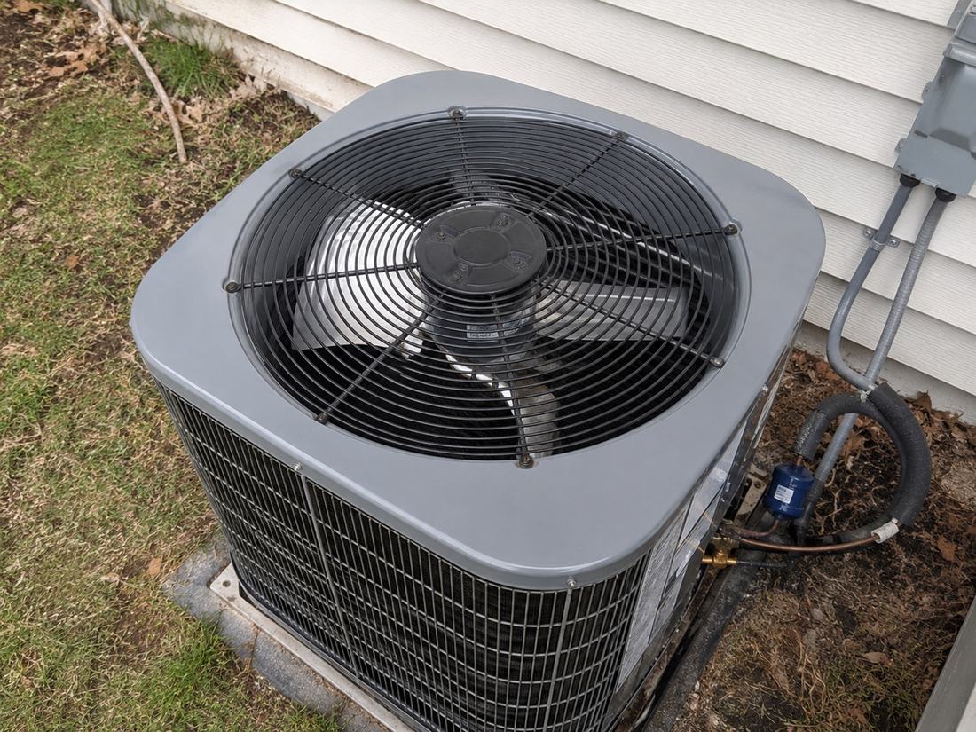 Outdoor air conditioner condenser inspected during residential HVAC maintenance.